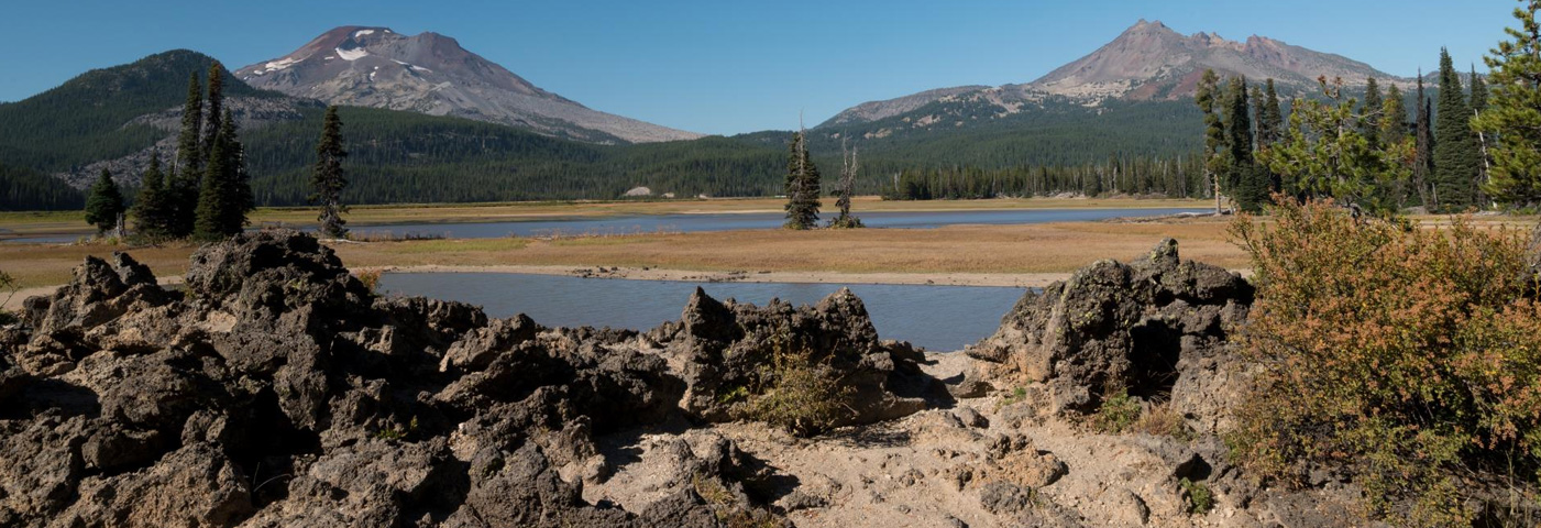 Three Sisters Mountains in late summer, Sparks Lake in the foreground at very low water levels.